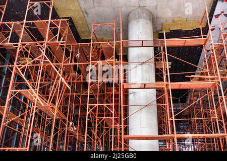 Colonna di calcestruzzo tra ponteggi metallici sulla costruzione di un nuovo edificio. Foto Stock