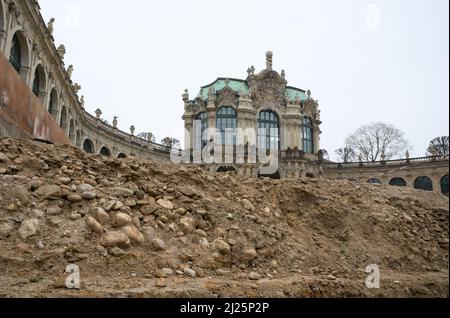 30 marzo 2022, Sassonia, Dresda: Pietre e terra si trovano sul bordo degli scavi archeologici dell'Ufficio di Stato per l'Archeologia in Sassonia, nel cortile interno dello Zwinger di Dresda. Durante le indagini, di fronte al Wallpavillon, sul lato ovest, sono state scoperte fondazioni ben conservate di bacini idrici. Data dalla prima fase del sito. La superficie totale di circa 14.000 metri quadrati tra l'insieme di edifici del 18th e 19th secoli è stata indagata per un anno da uno storico architettonico e due assistenti. Foto: Robert Michael/d Foto Stock