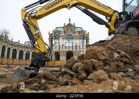 30 marzo 2022, Sassonia, Dresda: Un escavatore si trova ai margini degli scavi archeologici dell'Ufficio di Stato per l'Archeologia in Sassonia, nel cortile interno dello Zwinger di Dresda. Durante le indagini, di fronte al Wallpavillon, sul lato ovest, sono state scoperte fondazioni ben conservate di bacini idrici. Data dalla prima fase del sito. La superficie totale di circa 14.000 metri quadrati tra l'insieme di edifici del 18th e 19th secoli è stata indagata per un anno da uno storico architettonico e due assistenti. Foto: Robert Michael/dp Foto Stock