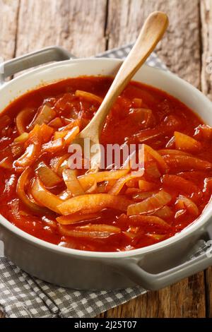 Cebolada è una tradizionale salsa portoghese o pasta fatta con cipolle come ingrediente chiave primo piano in pentola su un tavolo di legno. Verticale Foto Stock