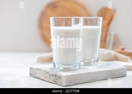 Primo piano del latte in due bicchieri su uno sfondo chiaro. Foto Stock