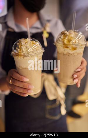 Frullato glassato al cioccolato con ciambelle e dolci. Folle freakshake alimentare tendenza. Spazio di copia Foto Stock