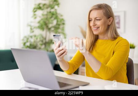 Donna che ha una chat video a casa Foto Stock