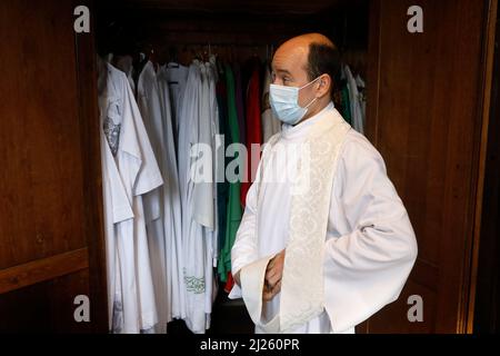 Messa Domenica nella chiesa di Saint Nicolas, Beaumont-le-Roger, Eure, Francia. Sacerdote vestito nella sacrestia Foto Stock