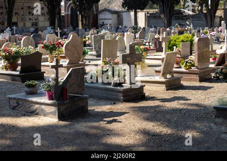 Cimitero italiano con lapidi e fiori artificiali in una giornata estiva di sole a Venezia, Isola di San Michele. Commemorazione dei morti, deat Foto Stock