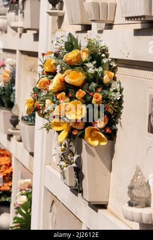 Cimitero murale italiano con lapidi e fiori artificiali in una soleggiata giornata estiva a Venezia, Isola di San Michele. Commemorazione dei morti, Foto Stock