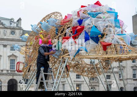 Londra, Regno Unito. 30 marzo 2022. L'artista filippino Leeroy New Poses a ‘The Arks of Gimokudan’, la sua installazione svelata a Somerset House per celebrare l'occasione della Giornata della Terra. Questa è la prima installazione britannica di New e comprende tre fantastiche navi ribaltate costruite utilizzando rifiuti di plastica e materiali riciclati. L'installazione, in mostra al 26 aprile, attinge alla cultura e mitologie delle Filippine, un paese in prima linea del clima emergenza credito: Stephen Chung / Alamy Live News Foto Stock