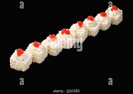 Sushi roll giapponese con salmone fritto, granchio di neve, capesante, formaggio Philadelphia, caviale tobiko, Palle di riso, maionese giapponese. Isolato sul dorso nero Foto Stock