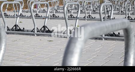 Primi piani di un gruppo di moderni portabiciclette a forma di staffa su un ampio parcheggio pubblico Foto Stock