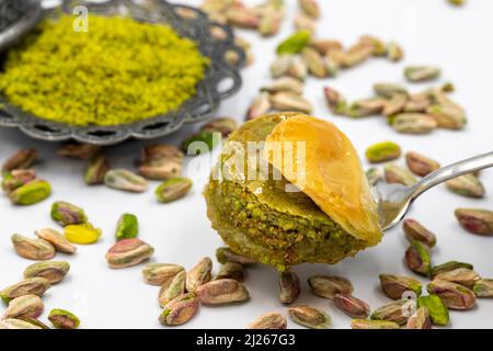 Baklava con pistacchio su sfondo bianco. Prelibatezze della cucina tradizionale turca. Nome locale fıstıklı dilber dudagi baklava Foto Stock