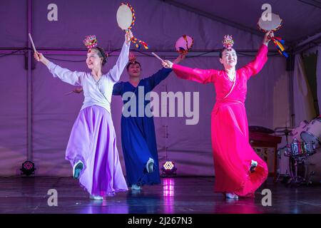 Ballerine coreane in abiti hanbok che tengono sogo (tamburi a mano) e si esibiscono sul palco. Festa di metà autunno, Auckland, New Zelaand Foto Stock