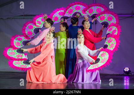 Un gruppo di donne coreane in abiti hanbok che eseguono un buchaechum, una danza tradizionale fan Foto Stock