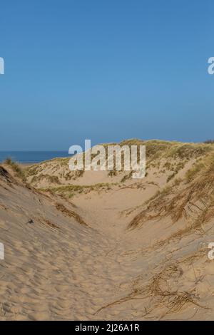 Guardando tra le dune di sabbia ricoperte di marram verso il mare, a Formby in Merseyside Foto Stock