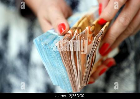 Donna in possesso di banconote e banconote in euro. Concetto di rubare denaro, persone ricche, risparmi o spendere denaro. Pagamento in conto. Foto Stock