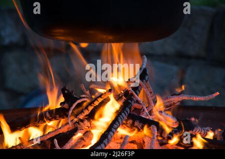 Cottura nel bollitore sopra il recipiente del fuoco Foto Stock