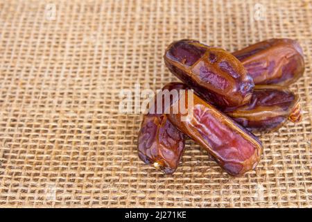 Date essiccate. Pila di frutta di data su sfondo burlap. Spazio per il testo. Foto Stock