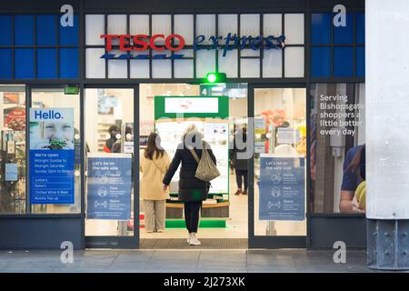 Le persone entrano in un negozio Tesco nel centro di Londra dopo che è entrato in vigore il rilassamento delle regole del piano B di Covid-19. Foto Stock