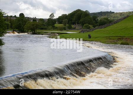 Una coppia fa una passeggiata lungo il fiume Wharfe nella Yorkshire Dales vicino alla città mercato di Grassington. Lo Yorkshire Dales è un'area montana della Foto Stock