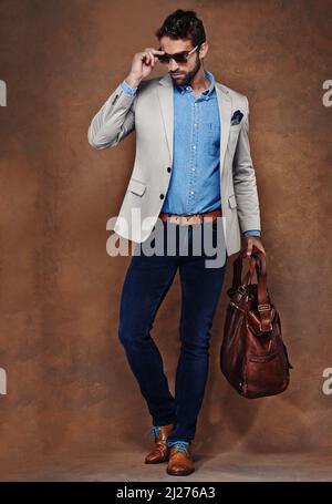 Il suo stile in movimento. Studio girato di un giovane uomo vestito elegantemente. Foto Stock