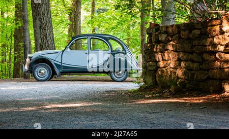 Auto antica verde due cavalli di potenza parcheggiata su una strada di ghiaia vicino a un muro di pietra in estate, sul Monte St-Bruno, Quebec, Canada. Foto Stock