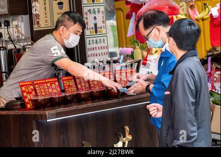 Hong Kong. 30th Mar 2022. Un uomo dispensa tisane medicinali nel suo negozio a North Point. Il governo di Hong Kong ha attivamente promosso l'uso della medicina tradizionale cinese per il trattamento di COVID-19. Tuttavia, gli esperti sono preoccupati che non vi siano prove sufficienti da studi controllati da parte di colleghi sull'efficacia di questi trattamenti per il nuovo coronavirus. (Foto di ben Marans/SOPA Images/Sipa USA) Credit: Sipa USA/Alamy Live News Foto Stock