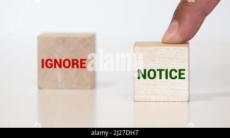 Indicazioni del cartello in legno con due frecce opposte su foglie verde dello sfondo. Ignora avviso versus segnaletica direzionale, scelta Concetto di immagine Foto Stock