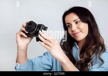 Giovane donna attraente sta scattando una foto usando la macchina fotografica digitale Foto Stock