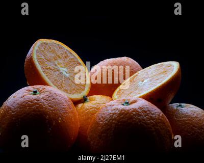 Macro fotografia di alcune arance succose su sfondo nero Foto Stock
