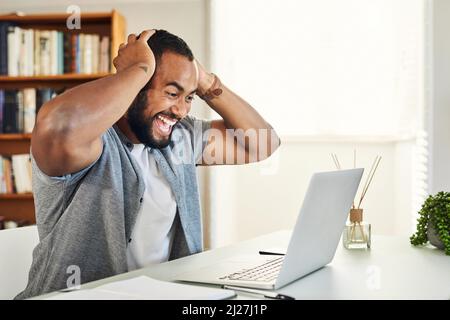 Ho appena segnato grande. Scatto di un bel uomo d'affari che guarda eccitato mentre lavora da casa. Foto Stock