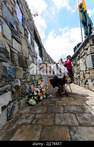 27/06/2010. Belfast, Irlanda del Nord. Una donna depone una weath floreale al nuovo giardino commemorativo repubblicano a Short Strand. Foto Stock