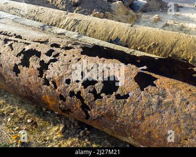 Tubi in metallo arrugginiti e fuoriuscenti per l'alimentazione e il riscaldamento dell'acqua Foto Stock