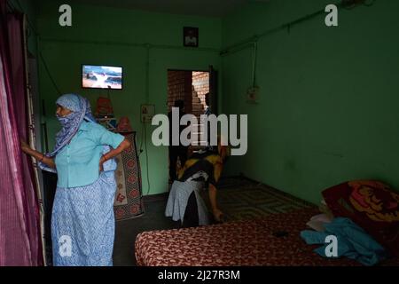 Una vecchia donna vestita tradizionalmente in una tipica casa modesta a Noida, India. Foto Stock