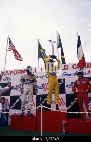 Ayrton Senna da Silva (BRA) Lotus 1st posizione, Nelson Piquet (BRA) Williams 2nd posizione e Alain Prost (fra) McLaren 3rd posizione festeggiano il podio Foto Stock