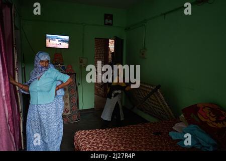 Una vecchia donna vestita tradizionalmente in una tipica casa modesta a Noida, India. Foto Stock