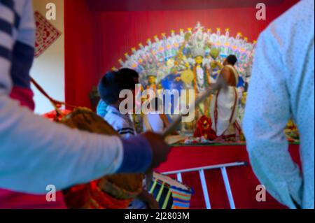 Immagine sfocata di Howrah, Bengala Occidentale, India. La dea Durga viene adorata dal sacerdote indù con santo camore. Dhaakis stanno giocando a dhaaks.Durga puja Foto Stock