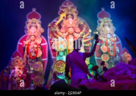 Immagine sfocata della Dea Durga è adorata dal sacerdote indù con specchio. VOG, il cibo santo viene offerto a Durga. Il più grande festival di Hind Foto Stock