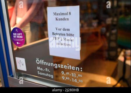 Amburgo, Germania. 30th Mar 2022. 'Massimo 8 clienti - si prega di mettere su FFP2 maschera prima di entrare' legge un cartello sulla porta d'ingresso di un negozio al dettaglio. Credit: Jonas Walzberg/dpa/Alamy Live News Foto Stock