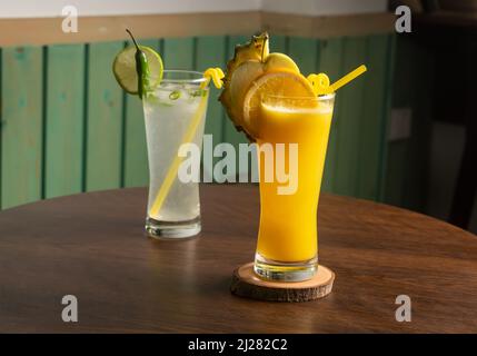 Un bicchiere di succo di cocomero agitare con limone piccante, cocomero crudo, paglia isolata sul tavolo di legno vista bevanda sana per la vitamina C. Foto Stock