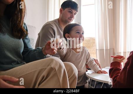 I genitori si divertono con i propri figli mentre si rilassano a casa. Foto Stock