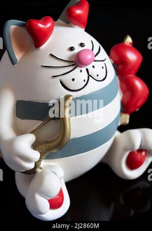 Una cassa di denaro di novità sotto forma di un gatto di cupide di caricatura. Foto Stock