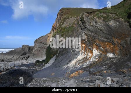 Baia di Sandymouth con aspre scogliere distorte che torreggiano sulla spiaggia rocciosa, sulla costa atlantica di North Cornwall.UK Foto Stock