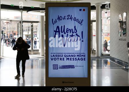 Nizza, Francia. 29th Mar 2022. Uno shopper passa davanti a un annuncio digitale sulle elezioni presidenziali francesi del 2022 in un centro commerciale. Il primo turno delle elezioni presidenziali francesi del 2022 si svolgerà domenica 10th aprile 2022. Credit: SOPA Images Limited/Alamy Live News Foto Stock