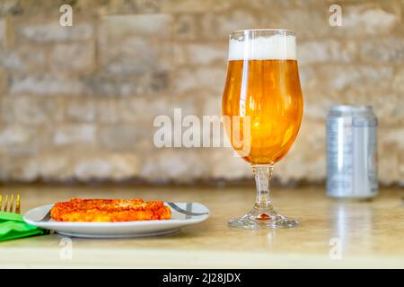 Bicchiere di birra fredda e gustosa pizza al tavolo del ristorante Foto Stock