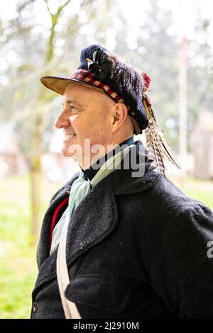 Attore storico di rievocazione per il periodo natalizio al Fort Nisqually Living History Museum che recita e vestita come scozzese della metà del 19th secolo f Foto Stock