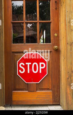 Cartello di stop sulla porta di ingresso in legno. Foto Stock