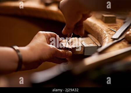 Lavorare con le mani è la forma d'arte più pura. Una persona che utilizza un attrezzo per lavorare su un pezzo di legno. Foto Stock