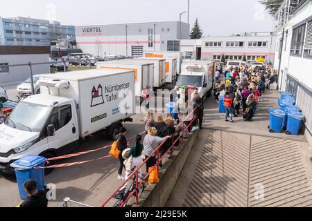 Norimberga, Germania. 29th Mar 2022. La maggior parte dei rifugiati ucraini si allineano di fronte alla banca alimentare di Norimberga per ricevere il loro cibo. Le banche alimentari in Germania riferiscono un enorme afflusso dall'inizio della guerra in Ucraina. Allo stesso tempo, stanno lottando con l'aumento dei prezzi dell'energia e del carburante. Credit: Nicolas Armer/dpa/Alamy Live News Foto Stock