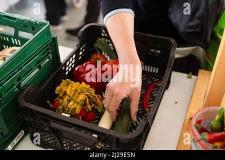 Norimberga, Germania. 29th Mar 2022. Una persona prende le verdure dalla banca del cibo nell'edificio Tafel Norimberga. Le banche alimentari in Germania riferiscono un enorme afflusso di persone dall'inizio della guerra in Ucraina. Allo stesso tempo, devono affrontare l’aumento dei prezzi dell’energia e del carburante. Credit: Nicolas Armer/dpa/Alamy Live News Foto Stock