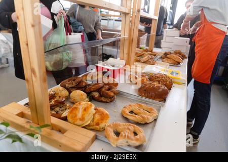 Norimberga, Germania. 29th Mar 2022. Principalmente i rifugiati ucraini si allineano alla banca alimentare di Norimberga. Le banche alimentari in Germania hanno riportato un enorme afflusso di persone dall'inizio della guerra in Ucraina. Allo stesso tempo, stanno lottando con l'aumento dei prezzi dell'energia e del carburante. Credit: Nicolas Armer/dpa/Alamy Live News Foto Stock