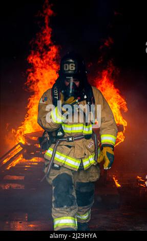 Un vigile del fuoco con installazioni di corpi marini Pacific Fire and Emergency Services esce da una sala di combustione durante un esercizio bilaterale di addestramento sul fuoco a Camp Hansen, Okinawa, Giappone, 25 marzo 2022. MCPIMAC F&ES e il Dipartimento dei vigili del fuoco di Naha City hanno assemblato e condotto corsi di formazione sul fuoco per confrontare le diverse tecniche e metodi di estinzione utilizzati da ciascun reparto per svolgere la stessa missione. (STATI UNITI Foto del corpo marino di CPL. Alex Fairchild) Foto Stock